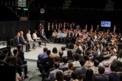 Hong Kong Chief Executive Carrie Lam, center on the stage, attends a community dialogue at the Queen Elizabeth Stadium in Hong Kong, Sept. 26, 2019.