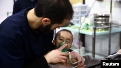 A man with a child at a hospital in the besieged town of Douma, Eastern Ghouta, Damascus, Syria Feb. 25, 2018. 