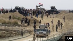 Lực lượng an ninh Iraq tập trung gần một cây cầu tạm được xây dựng bởi các kỹ sư quân đội Iraq ở phía nam Ramadi, trong chuyến thăm của Thủ tướng Iraq Haider al-Abadi ngày 29 tháng 12 năm 2015, sau khi lực lượng chính phủ chiếm lại thành phố từ Nhà nước Hồi giáo.