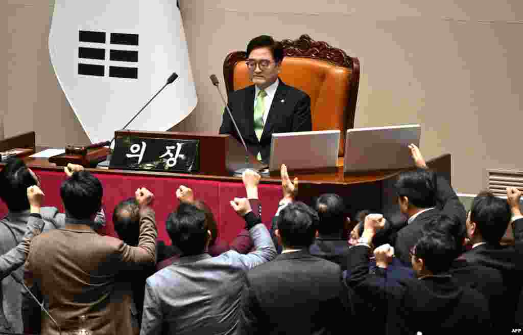 South Korea&#39;s ruling People Power Party lawmakers, bottom, argue to National Assembly Speaker Woo Won-shik during the plenary session for the impeachment vote of acting president Han Duck-soo at the National Assembly in Seoul.