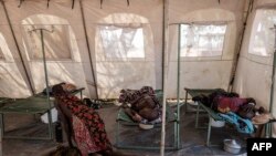 FILE - Patients suffering from cholera receive treatment inside a tent converted into a temporary field hospital near the remote village of Dor, Sudan, April 28, 2017.