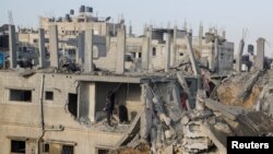 Palestinians inspect the site of Israeli strikes in Khan Younis