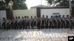 Police officers stand guard behind a razor wire barricade during a rally against persecution of Myanmar's Rohingya Muslim minority, outside Myanmar Embassy in Jakarta, Indonesia, Sept. 4, 2017.