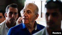 Former Israeli Prime Minister Ehud Olmert (C) leaves Tel Aviv District Court, May 13, 2014.