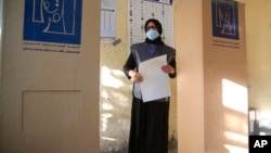 An Iraqi woman casts her vote at a polling center in Baghdad, Oct. 10, 2021. 