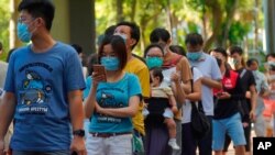 People queue up to vote in Hong Kong, July 12, 2020, in an unofficial primary for pro-democracy candidates ahead of legislative elections in September. 
