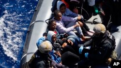 Des migrants sont transportés dans un canot de la Marine allemande lors d’une opération de sauvetage dans la mer Méditerranée au large des côtes de la Libye, 29 mars 2016.