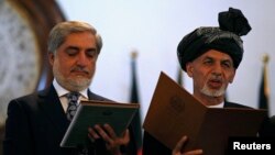 Afghanistan's new President Ashraf Ghani, right, and Afghanistan's Chief Executive Abdullah Abdullah take the oath during their inauguration in Kabul, Sept. 29, 2014. 