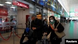 A woman wears a protective face mask at Roma Termini railway station, after the Italian government imposed a virtual lockdown on the north of the country, in Rome, March 8, 2020.