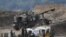 Israeli soldiers stand next to an artillery unit on the Israeli side of the border with Lebanon, August 6, 2021. 