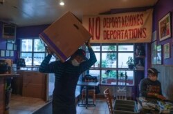 A worker lifts a box containing prepared meals at La Morada, an award winning Mexican restaurant in South Bronx, Wednesday Oct. 28, 2020, in New York.