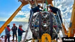 เครื่องตรวจจับนิวตริโน ขณะรับการตรวจสอบจากทีมเจ้าหน้าที่ (แฟ้มภาพ/Reuters)