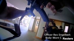 Metropolitan Nashville Police Department Officer Rex Engelbert points his weapon at the mass shooting suspect in The Covenenant School