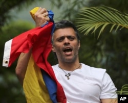 FILE - Venezuela's opposition leader Leopoldo Lopez holds a national flag as he greets supporters outside his home in Caracas, Venezuela, following his release from prison.