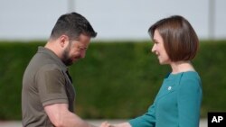 Predsjednica Moldavije Maia Sandu, desno, pozdravlja ukrajinskog predsjednika Volodymyra Zelenskyyja u Bulboaci, Moldavija, 1. juna 2023. Ona je česta meta online dezinformacija stvorenih umjetnom inteligencijom. (AP Photo/Vadim Ghirda, fajl)