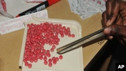 FILE: a health worker counts antiretroviral drug tablets for a patient at The AIDS Support Organization (TASO) in the capital Kampala, Uganda, July 12, 2012. 