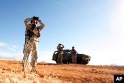 FILE - In this Jan. 19, 2007, photo, a National Guard unit patrols at the U.S.-Mexico border in Sasabe, Arizona.