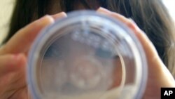Brigitte Enriquez, 2 tahun, menghabiskan segelas susu saat makan pagi di Howard Area Family Center, Chicago (foto: AP Photo/Nam Y. Huh)