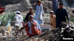 North Waziristan sits in front of a food handout distribution point for internally displaced persons in Bannu, located in Pakistan's Khyber-Pakhtunkhwa province, July 6, 2014.