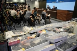 Police hold a news conference with confiscated evidence seen at front, the police headquarters in Hong Kong, July 6, 2021.