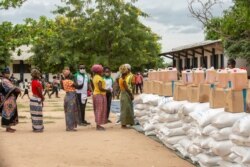 FILE - Women wait in line during the United Nations World Food Program's distribution at a school in Matuge district, northern Mozambique, Feb. 24, 2021.