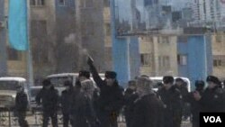 Polisi menembakkan pistol ke udara untuk membubarkan demonstran di Zhanaozen, Kazakhstan (16/12).