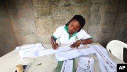 Wata ma'akaciyar Hukumar Zabe ta na aiki a rumfar zabe a Najeriya.