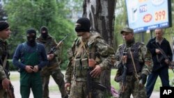FILE - Pro-Russian gunmen listen to instructions from their commander, center, behind barricades in Slovyansk, eastern Ukraine, Friday, May 2, 2014. 