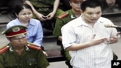 FILE - Nguyen Van Dai, right, testifies in this May 2013 file photo, originally taken from TV footage. The well-known Vietnamese human rights lawyer was arrested on anti-state "propaganda" charges.