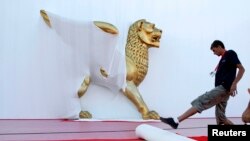 FILE - Staff prepare the red carpet in front of the Cinema Palace for the 65th Venice Film Festival in Venice, Aug. 25, 2008. The 75th edition of the world's oldest film festival kicks off in late August.