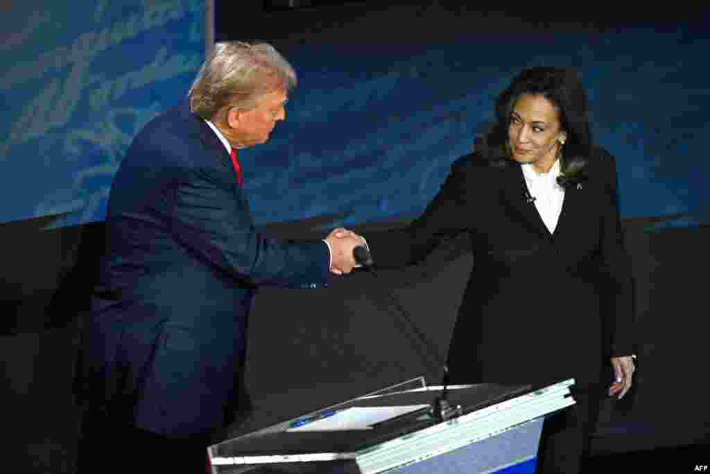 Mokonzi ya kala ya ekolo Amerika Donald Trump (G) na Vice-présidente mpe démocrate Kamala Harris (D) na libandeli lya bondongwani na bango na etando eke na&nbsp;National Constitution Center, Philadelphie, Pennsylvanie, 10 sanza ya libwa 2024.(Photo by SAUL LOEB / AFP)