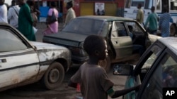 Un enfant mendie au milieu des voitures dans une rue de Medina Gounass à Dakar, Sénégal, 24 septembre 2013.