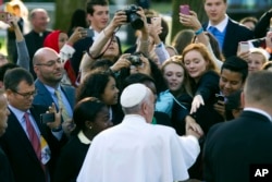 Pope Francis greets well-wishers while departing for the White House from the Apostolic Nunciature, the Vatican's diplomatic mission in Washington, Sept. 23, 2015.