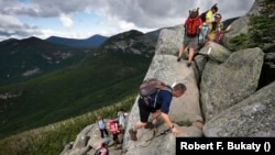 In this Saturday, Aug. 7, 2015 photo, day-hikers scramble over rocky boulders on the Appalachian Trail below the summit of Mt. Katahdin in Baxter State Park in Maine. (AP Photo/Robert F. Bukaty)