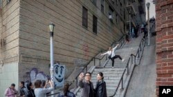 People pose on the steps between two apartment buildings in the Bronx borough of New York, Oct. 28, 2019. 