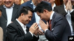 นพ.ชลน่าน ศรีแก้ว (ซ้าย) หัวหน้าพรรคเพื่อไทย พนมมือทักทายนายพิธา ลิ้มเจริญรัตน์ หัวหน้าพรรคก้าวไกล เมื่อ 17 พฤษภาคม 2566 (ที่มา: เอพี)