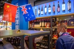 A visitor wearing a face mask to protect against the coronavirus looks at a display of Australian wines at the China International Import Expo in Shanghai on Nov. 5, 2020.