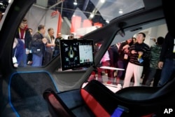 FILE - People crowd around the EHang 184 autonomous aerial vehicle at the EHang booth at CES International in Las Vegas, Jan. 6, 2016. The drone is large enough to fit a human passenger,