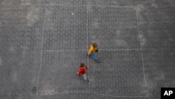 Ukrainian refugee children walk along the backyard of the Lauder Morasha Jewish school in Warsaw, Poland, Thursday, July 28, 2022. (AP Photo/Michal Dyjuk)