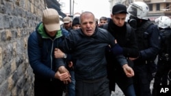 Plainclothes police detain a man in Istanbul, one of more than 200 people who were protesting peacefully against curfews and operations in mainly Kurdish cities and towns in southeastern Turkey, Jan. 3, 2016. 
