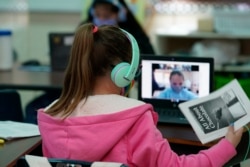 Students at Driggers Elementary School attend a class in-person as they interact with classmates virtually, Monday, Feb. 8, 2021, in San Antonio. (AP Photo/Eric Gay)