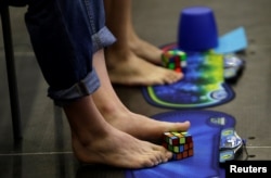Competitors solve Rubik's cubes using their feet during the Rubik's Cube European Championship in Prague, July 2016.