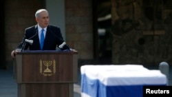 PM Israel Benjamin Netanyahu mengenang jasa-jasa mantan PM Ariel Sharon di dekat jenazahnya yang disemayamkan di gedung parlemen Israel sebelum dimakamkan hari Senin (13/1). 
