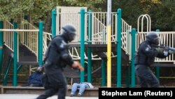 Participants act as victims as members of the University of California Berkeley Police Department secure the scene during an elementary school shooter scenario at Urban Shield 2013, in Castro Valley, California, October 26, 2013. 