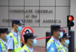 FILE - Policemen walk past the US consulate in Chengdu, southwestern China's Sichuan province, on July 26, 2020.
