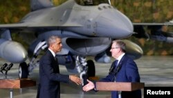 ប្រធានាធិបតី​អាមេរិក បារ៉ាក់ អូបាម៉ា ចាប់ដៃ​ជាមួយ​ប្រធានាធិបតី​ប៉ូឡូញ Bronislaw Komorowski នៅ​មុខ​យន្តហោះ​ចំបាំង​អាមេរិក​ធុន F-16នៅ​អាកាសយានដ្ឋាន​ទីក្រុង​វ៉ាសូវី​នៃ​ប្រទេស​ប៉ូឡូញ នៅ​ថ្ងៃ​ទី​៣ ​ខែ​មិថុនា ​ឆ្នាំ​២០១៤។