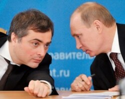 FILE - Russian Prime Minister Vladimir Putin, right, speaks to Vladislav Surkov, deputy prime minister in charge of economic modernization, during a visit in Kurgan, Russia, Feb. 13, 2012.