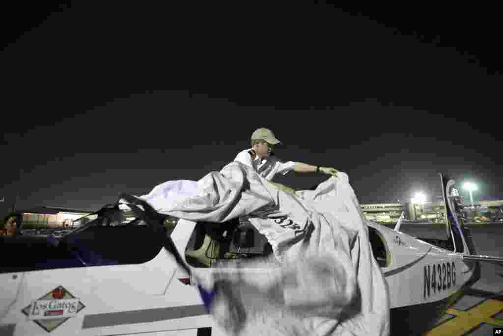 Pria AS, Jack Wiegand (20 tahun), dari Fresno, California, menutupi pesawat bermesin tunggal &#39;Mooney 20&#39; dengan kain di Manila, Filipina, setelah tiba dari Bangkok, Thailand pada kelima kali usahanya untuk menjadi pilot termuda yang berhasil terbang keliling dunia. 