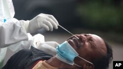 2일 인도네시아 발리에서 의료진이 신종 코로나바이러스 감염 검사 대상자의 검체를 채취하고 있다.