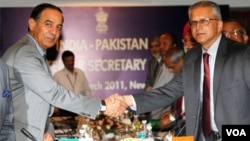 Sekretaris Negara India G.K. Pillay (kiri) berjabat tangan dengan Sekretaris Negara Pakistan Chaudary Qamar Zaman dalam pertemuan di New Delhi, Senin (28/3).